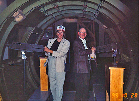 color picture of an elderly man and a younger woman standing inside a large aircraft